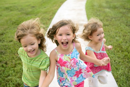 Three sister girls playing running on the park